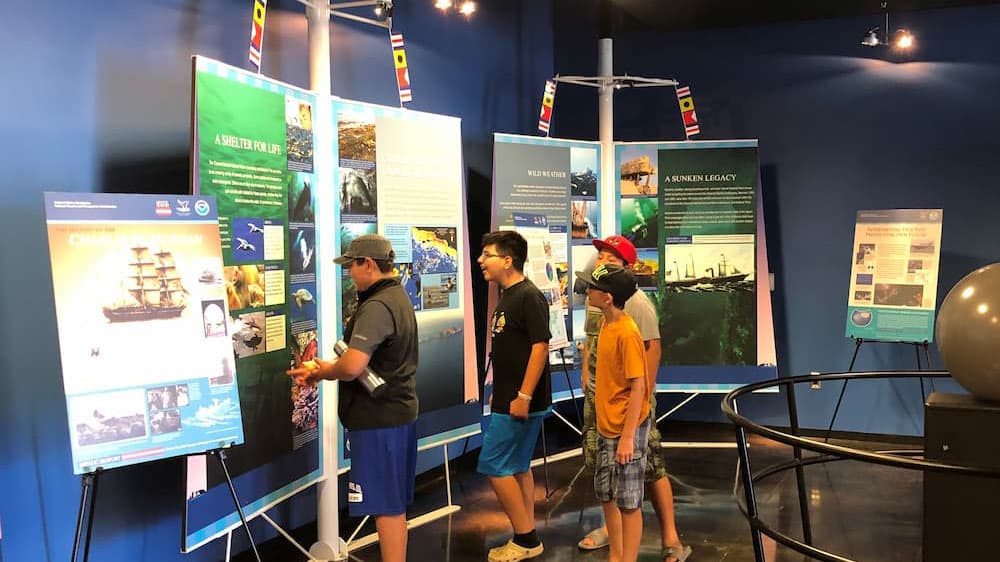 Visitors at a meusuem look at different exhibits