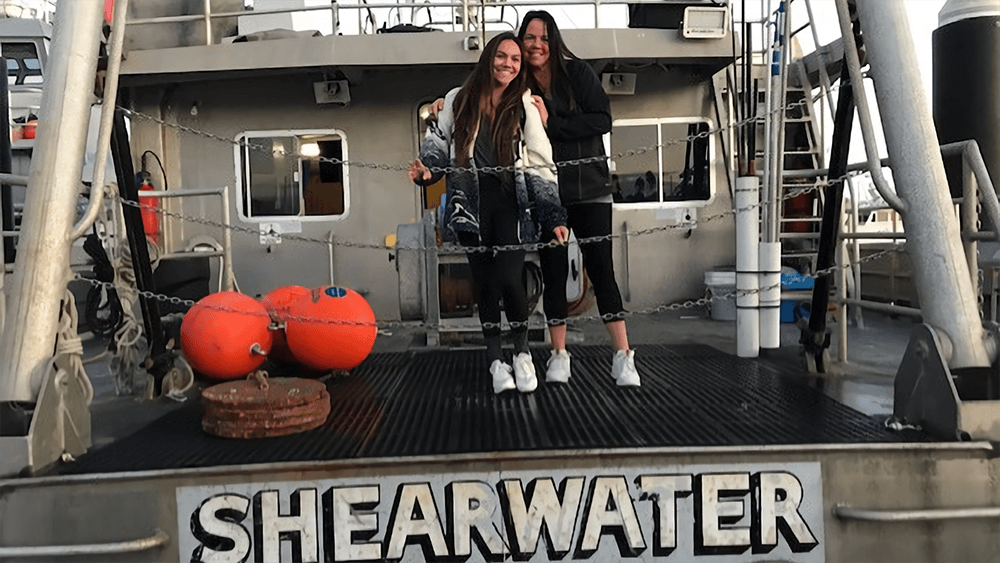 two people on the deck of a research vessel with the words shearwater on it