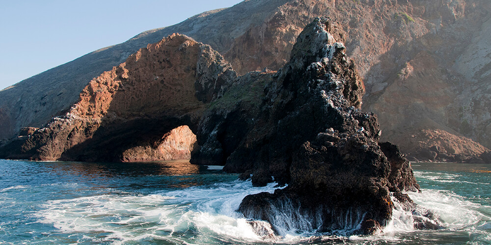 An arching rock formation on a coastline