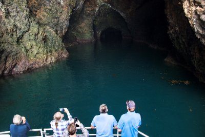 people on a boat about to enter a cave